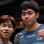 Aaron Tai and Yap Roy King pose together on court in their navy blue Malaysian national jerseys.