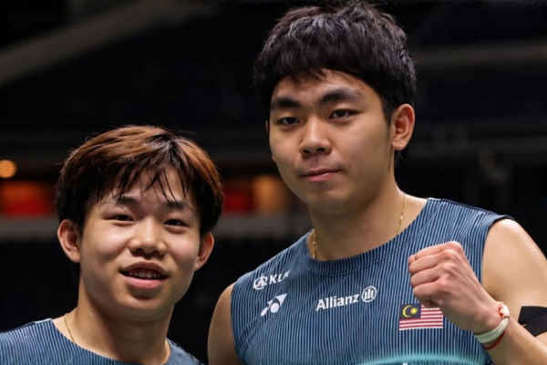 Aaron Tai and Yap Roy King pose together on court in their navy blue Malaysian national jerseys.