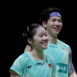 Chan Wen Tse and Chen Tang Jie smile together on court in their mint green Malaysian national jerseys.