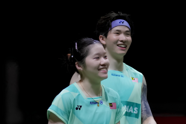 Chan Wen Tse and Chen Tang Jie smile together on court in their mint green Malaysian national jerseys.