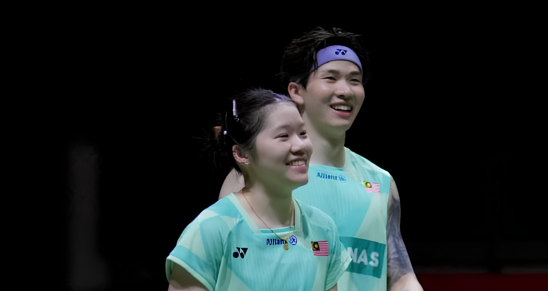 Chan Wen Tse and Chen Tang Jie smile together on court in their mint green Malaysian national jerseys.