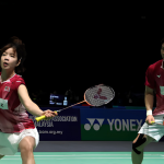 Shevon Lai Jemie executes a forehand return while Goh Soon Huat guards the back court in their red Malaysian jerseys.