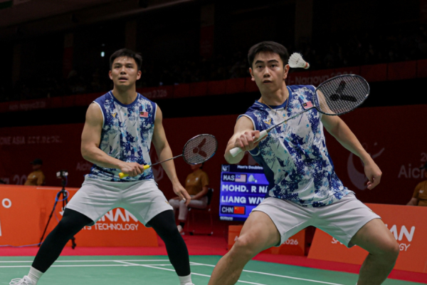 Nur Izzuddin Rumsani prepares to return the shuttlecock while Goh Sze Fei stays in ready position in their blue and white jerseys during the Asian Games.