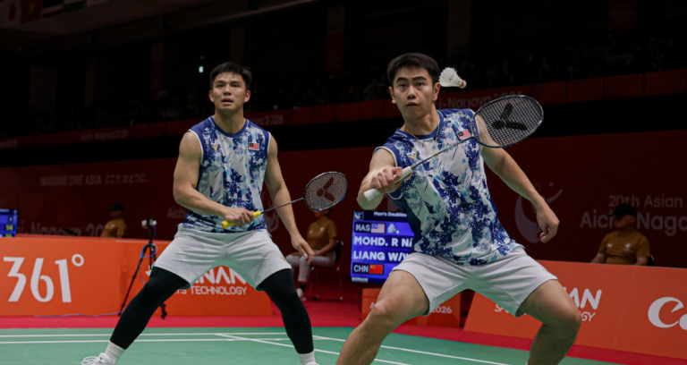 Nur Izzuddin Rumsani prepares to return the shuttlecock while Goh Sze Fei stays in ready position in their blue and white jerseys during the Asian Games.