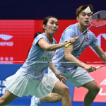 Lai Pei Jing lunges low at the net while Hoo Pang Ron tracks the shuttlecock in their light blue Malaysian jerseys.
