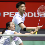 Hoo Pang Ron raises his racket to attack while Lai Pei Jing crouches at the net in their white jerseys.