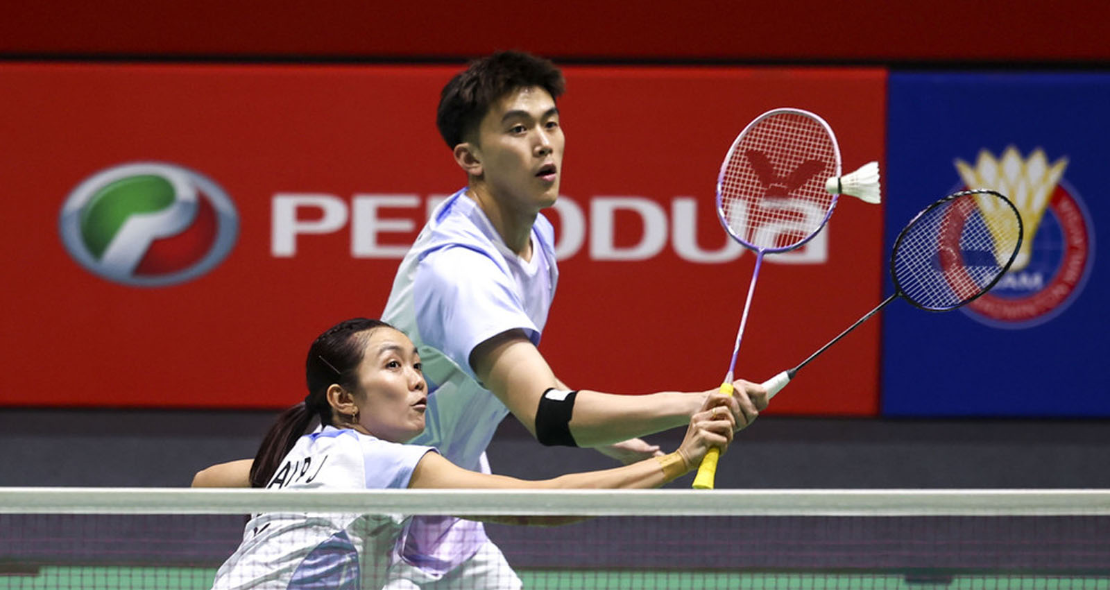 Lai Pei Jing intercepts the shuttlecock at the net while Hoo Pang Ron stays in defensive ready position in their pink jerseys during the French Open.