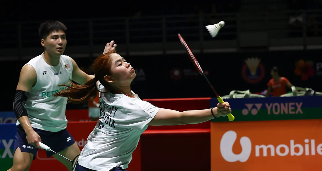 Cheng Su Yin extends her racket to play a net return while Jimmy Wong guards the rear court in their white jerseys.