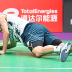 Leong Jun Hao lies exhausted on the green court floor pushing himself up in his Petronas jersey.