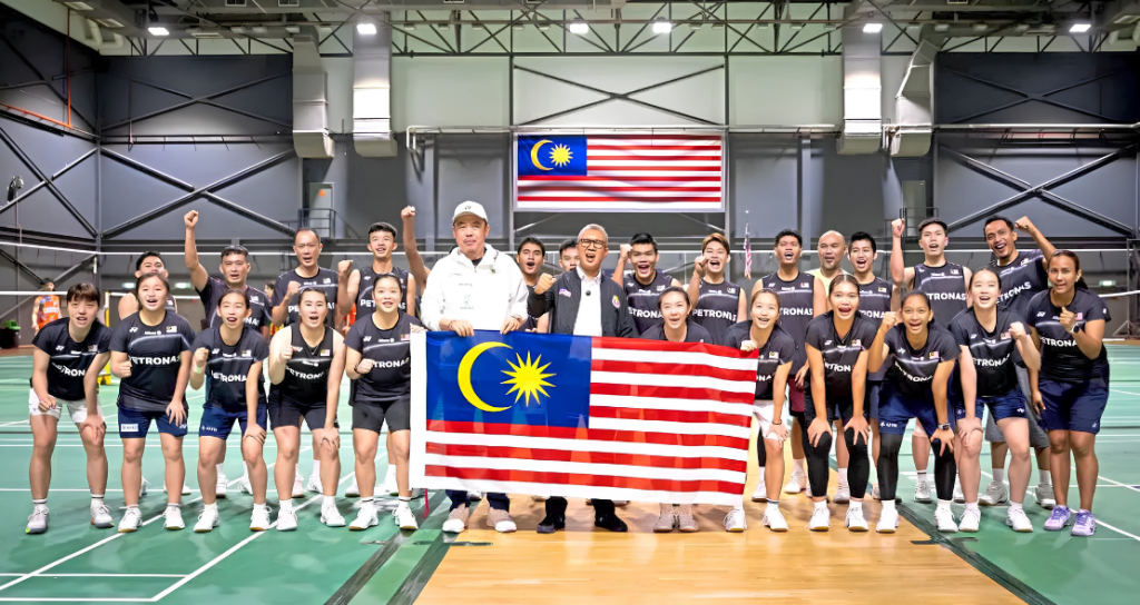 The Malaysian World Junior badminton squad and coaches pose together with the national flag ahead of the World Junior Championships in Cairo.