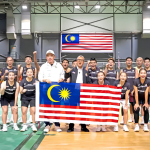 The Malaysian World Junior badminton squad and coaches pose together with the national flag ahead of the World Junior Championships in Cairo.