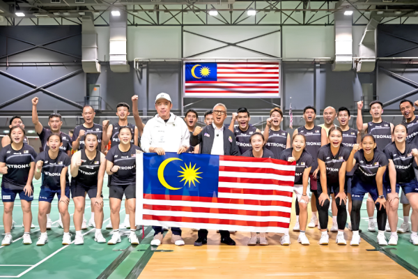 The Malaysian World Junior badminton squad and coaches pose together with the national flag ahead of the World Junior Championships in Cairo.