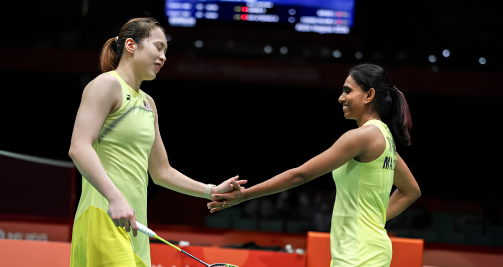 Pearly Tan and M. Thinaah smile as they hold hands in celebration wearing their lime green jerseys during the Asian Games.