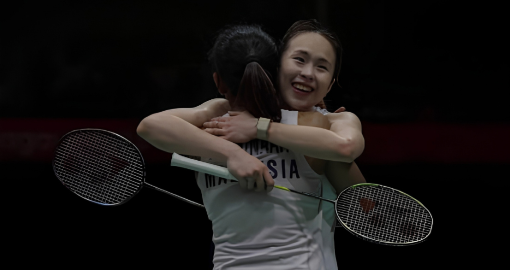 Pearly Tan embraces M. Thinaah in a warm celebratory hug on court with rackets in hand.