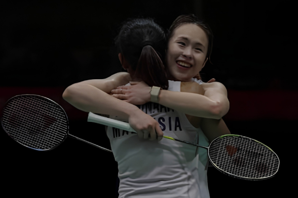 Pearly Tan embraces M. Thinaah in a warm celebratory hug on court with rackets in hand.