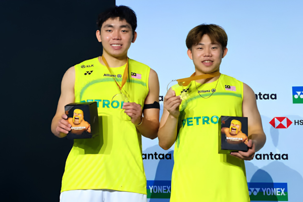 Yap Roy King and Aaron Tai smile on the podium holding their gold medals and tournament gifts at the Arctic Open.