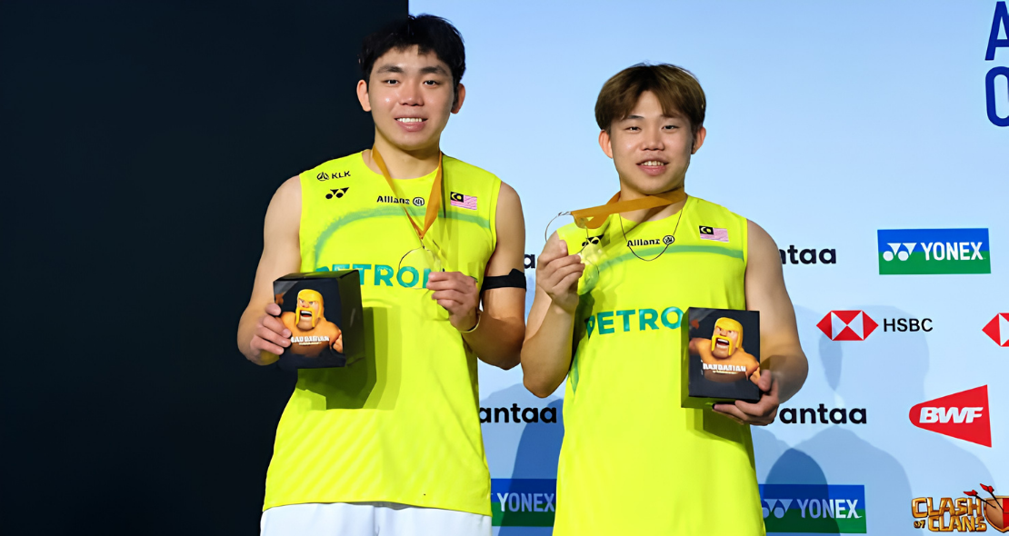 Yap Roy King and Aaron Tai smile on the podium holding their gold medals and tournament gifts at the Arctic Open.